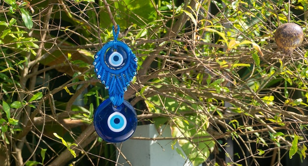 Close up of evil eye charms hang from a tree