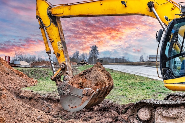 建設現場での掘削機バケットの接写 掘削機は地下ユーティリティ用の溝を掘っている 土工用建設機械