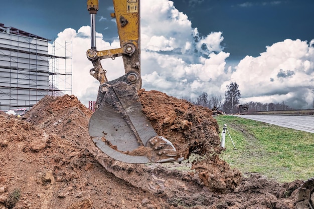 Close up of excavator bucket at construction site The excavator is digging a trench for underground utilities Construction equipment for earthworks