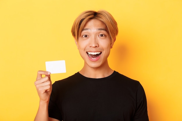 Close-up of excited surprised handsome asian guy