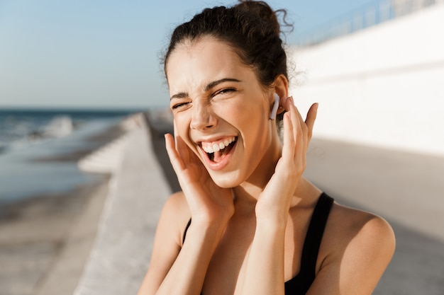 Close up of excited young sportswoman at the seaside