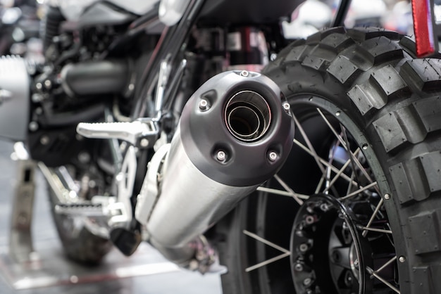 Close-up of exhaust or Intake of black sport racing Motorcycle with new tire and wheel in showroom. Low Angle Photograph Of Motorcycle.
