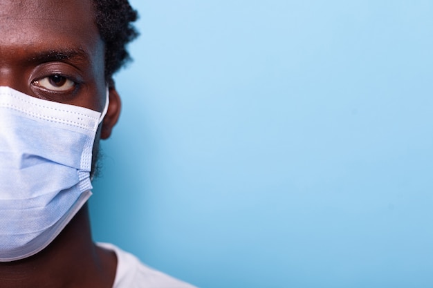 Close up of eye of african american adult wearing face mask