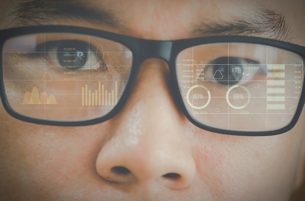 Close up eye in glasses with futuristic holographic interface to display data.future technology, internet concept.