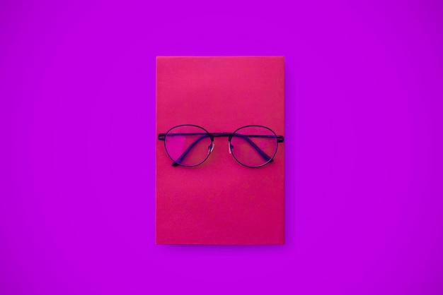 Close-up of eyeglasses against colored background