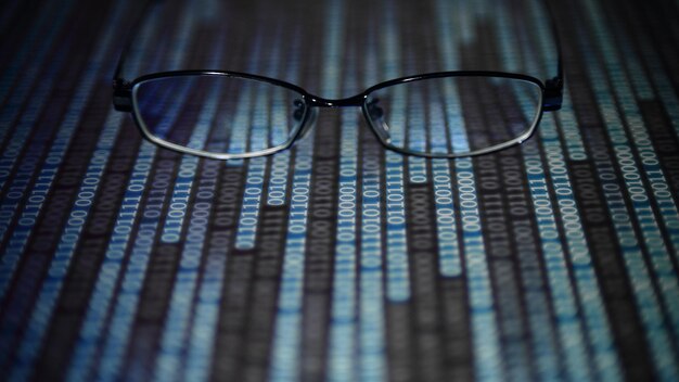 close-up of eyeglasses on binary codes