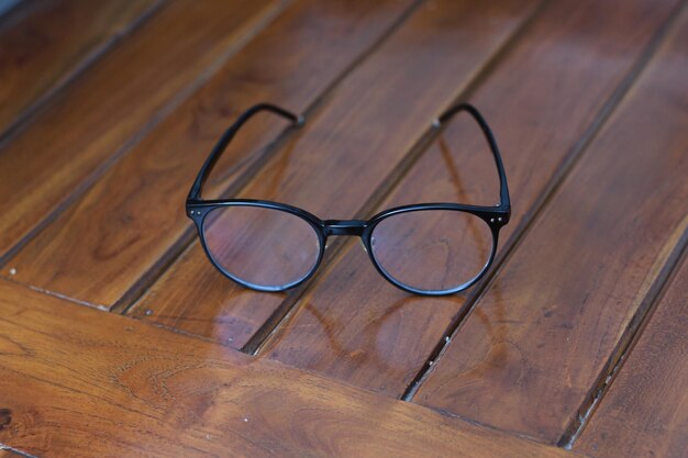 Photo close-up of eyeglasses on wooden table