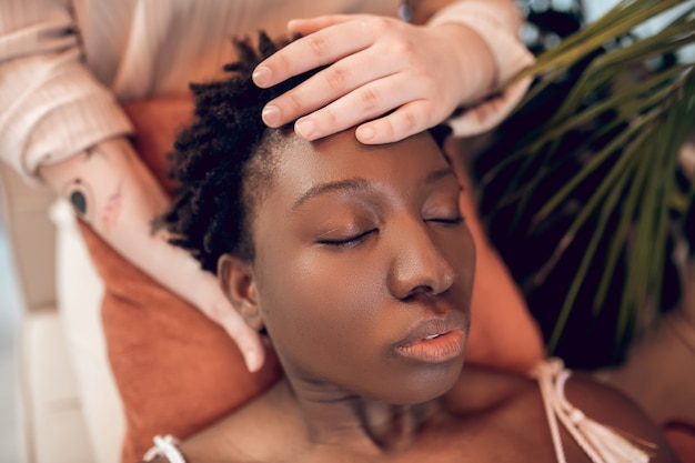 close-up face of african american woman and white hands