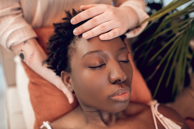 Close-up face of african american woman and white hands