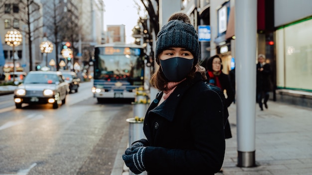 close up face of Asian woman tourist travel in Japan wearing face mask. Coronavirus flu virus travel concept