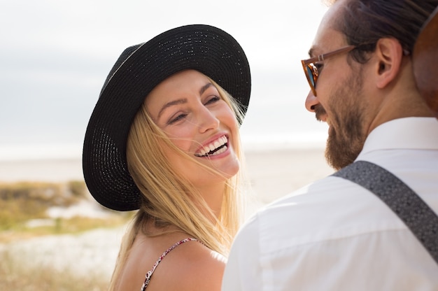 Close up face of cheerful young woman laughing with man outdoor