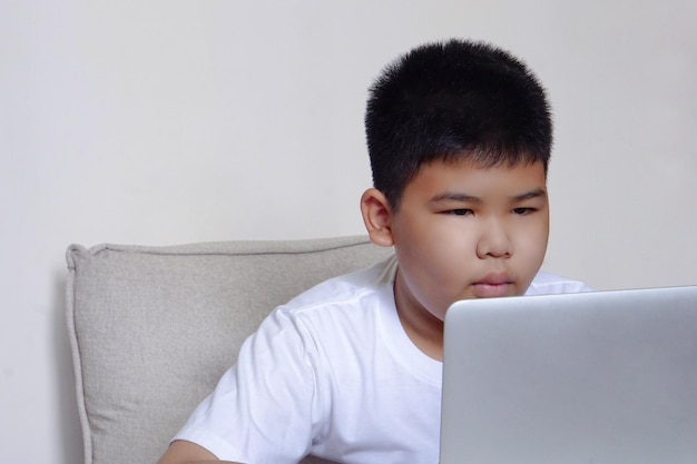 Close up face cute boy having fun watching laptop Education learning and technology concept