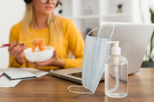 Photo close-up face mask and hand sanitizer on the desk