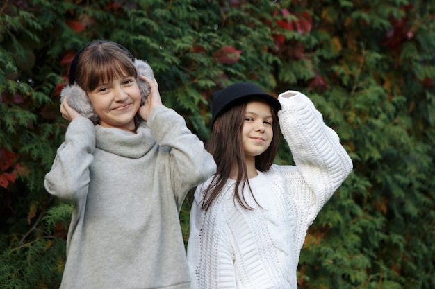 Close up fashion portrait of two sisters hugs and having fun together, wearing bright floral hats and stylish mirrored sunglasses, best fiend enjoy amazing time together.