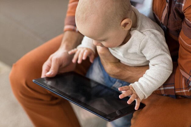 Photo close up of father and baby son with tablet pc