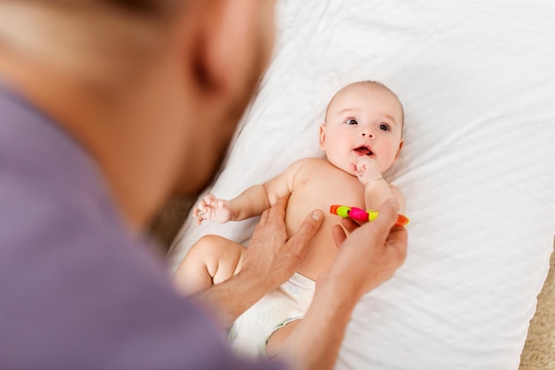 close up of father and baby with rattle toy