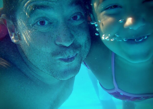 Photo close-up of father and daughter swimming in sea