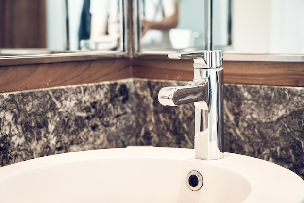 Photo close-up of faucet in bathroom at home