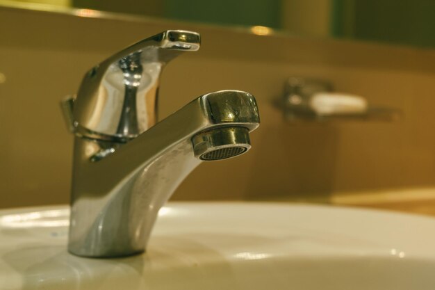 Close-up of faucet on table at home