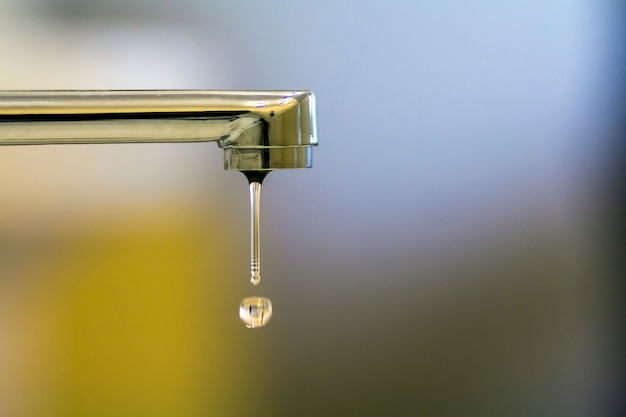 Close-up of faucet with turned drop water in modern bathroom