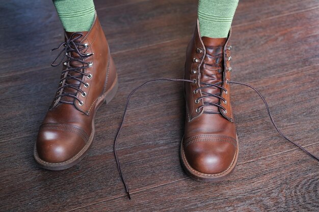 feet of man in green socks in stylish baroque leather boots on a