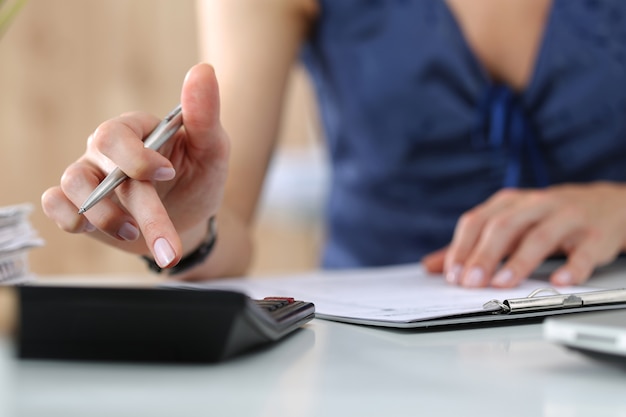 Close up of female accountant or banker making calculations. Savings, finances and economy concept