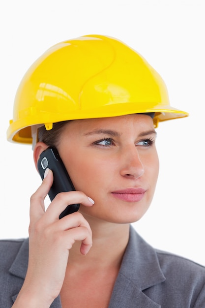 Photo close up of female architect on her cellphone with helmet on