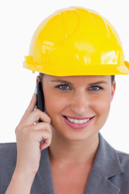 Close up of female architect with helmet on her cellphone