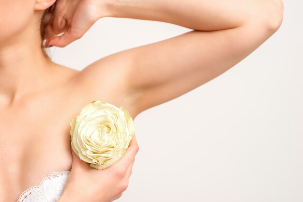 Close up of female armpit with white rose flower isolated on white background.