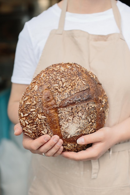 Close up of female baker holding freshly baked bread