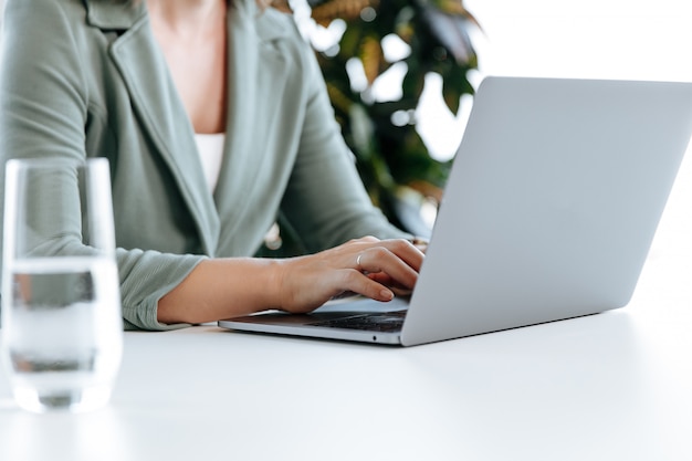 Close up of female business person working on laptop