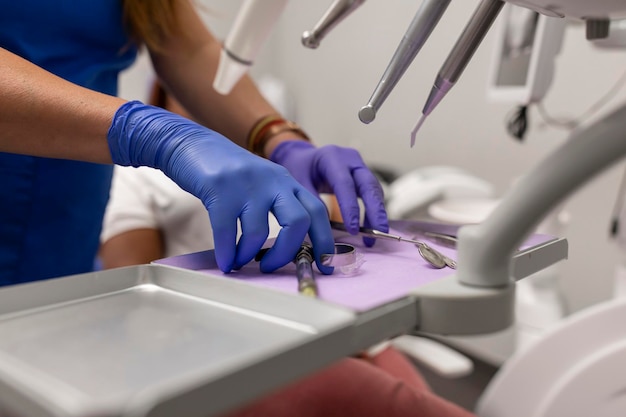 close up of a female dentist's hands grabbing some tools at the dental clinic