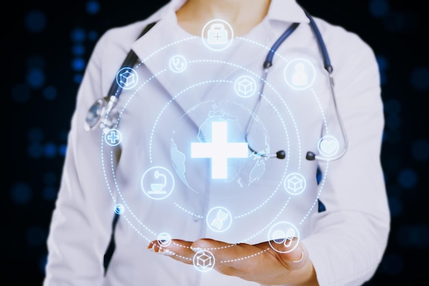 Close up of female doctor hand holding creative glowing blue medical hologram with cross and globe on blurry background Science healthcare system and futuristic pharmacy concept