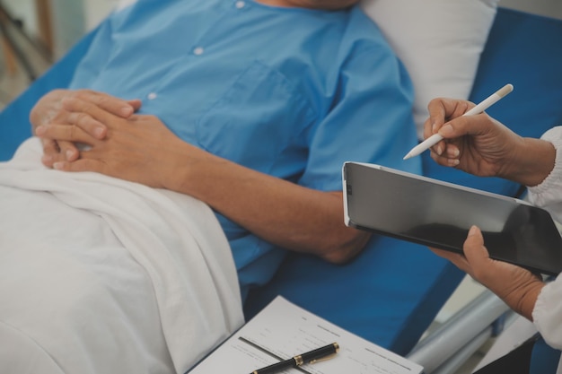 Close up of Female Doctor using stethoscope putting beat heart diagnose with patient in examination room at a hospital checkup body Medical and Health Care Concept