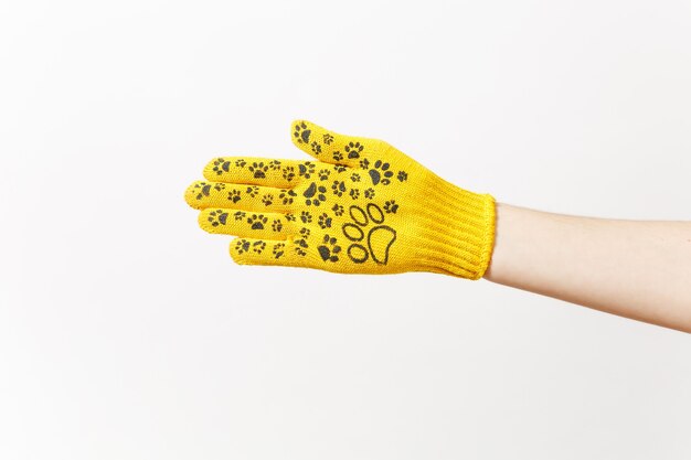 Close up of female hand in building yellow gloves with fun print isolated on white background. Instrument, accessories for renovation apartment room. Repair home concept. Copy space for advertisement.