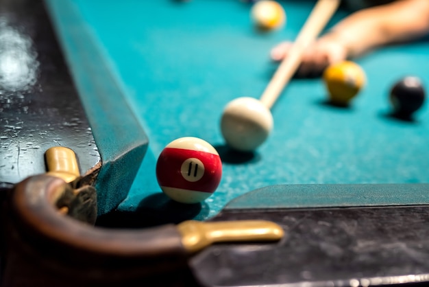 Photo close up of female hand hold cue and preparing aiming to shoot to pool balls