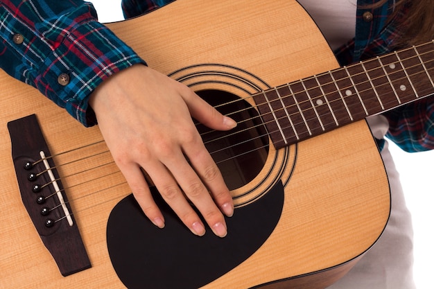 Крупным планом женская рука с гитарными струнами в студии