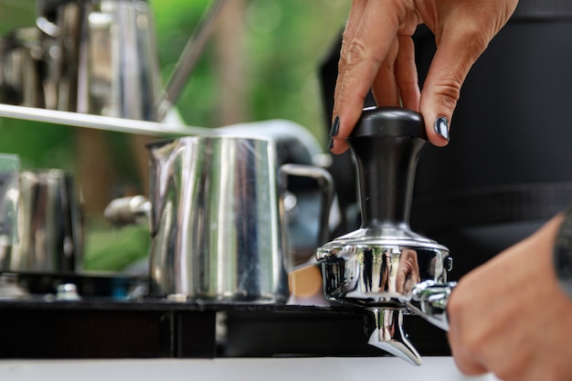 Close up of female hands. Barista is making coffee.