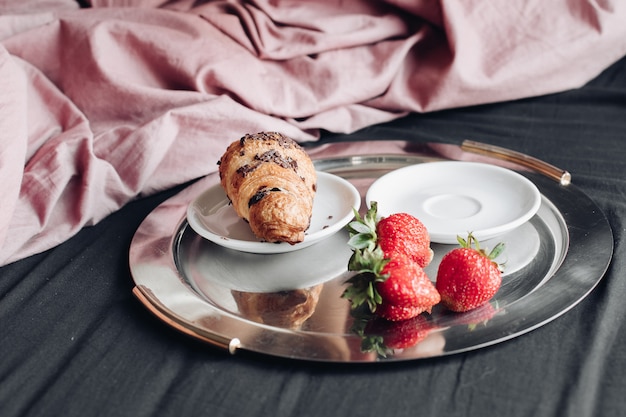 Close-up female hands enjoying weekend having appetizing breakfast in bed