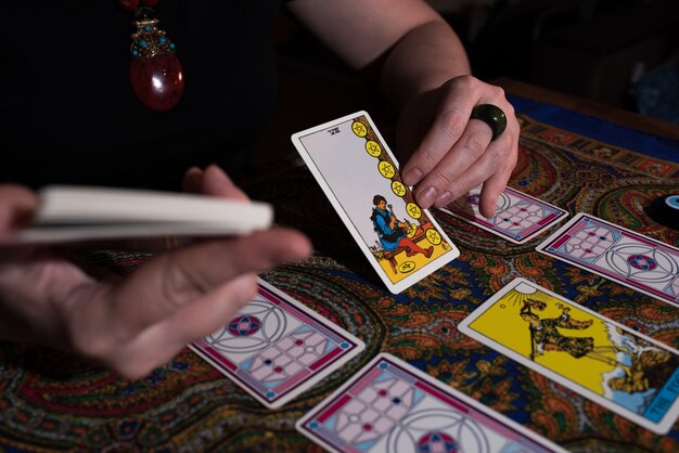 Close up female hands holding tarot cards. fortuneteller.\
witchcraft