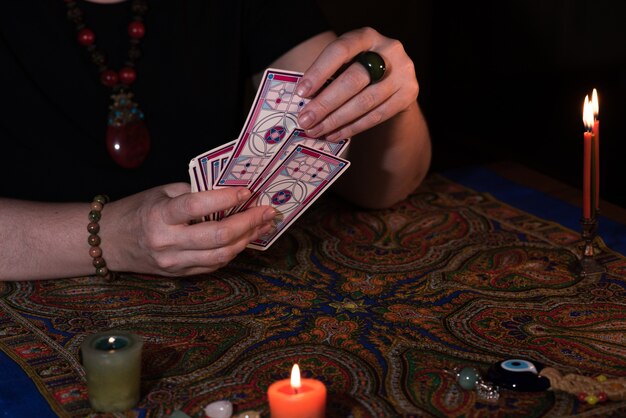 Close up female hands holding tarot cards. fortuneteller.\
witchcraft