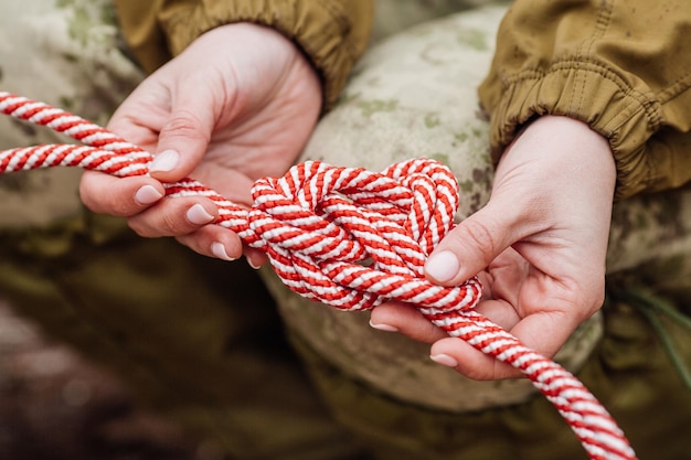 Photo close up of female hands tie a rope