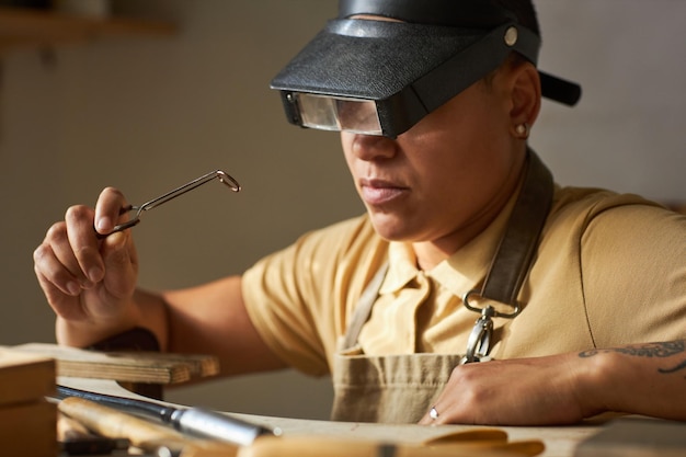 Close up of female jeweler wearing magnifying goggles