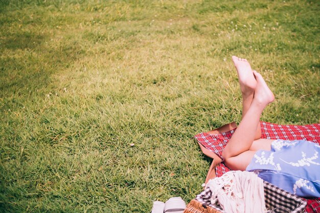 Close up of female legs enjoying picnic in a park.