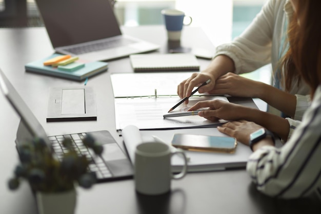 Close-up of female manager working with her team to managing the financial budget for new campaign.