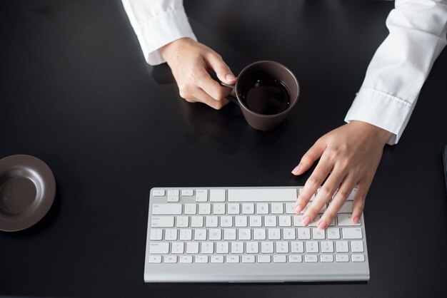 Close up of female office worker typing on the keyboard on desk office