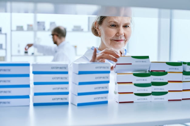 Foto avvicinamento. farmacista femminile in piedi davanti a uno scaffale di medicinali. foto con copia-spazio.