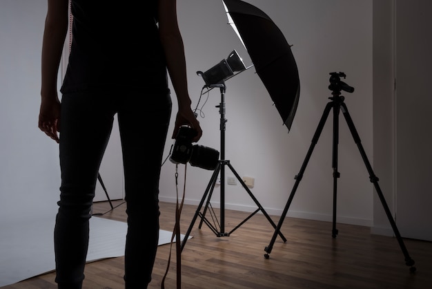 Foto primo piano di una macchina fotografica femminile della tenuta del fotografo nello studio della foto