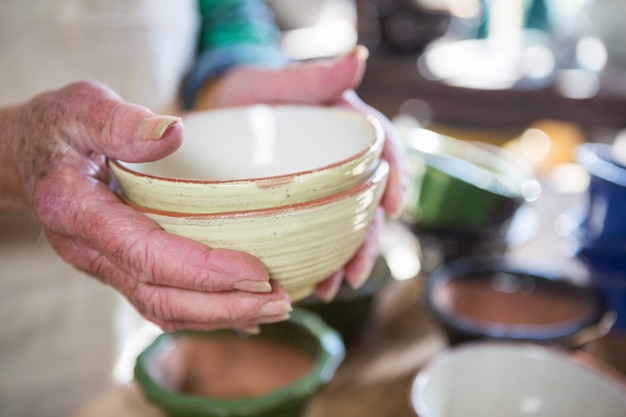 Close-up of female potter holding bowl