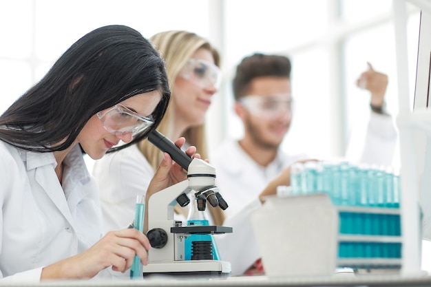 Photo close up. a female scientist uses a microscope for research in a laboratory